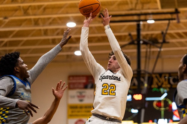 Marian Catholic's Zack Sharkey (22) with a fade-away jumper over a pair of De La Salle defenders during a nonconference game in Chicago Heights on Friday, Feb. 21, 2025. (Vincent D. Johnson / for the Daily Southtown)