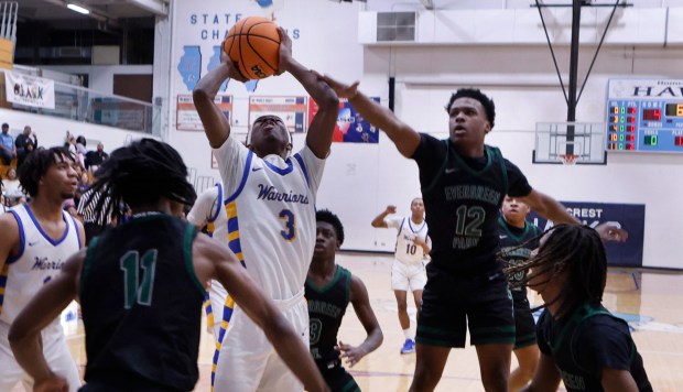 Crete-Monee's Jaydon Watts (3) lays his shot up between three Evergreen Park defenders during a Class 3A Hillcrest Regional semifinal basketball game on Wednesday Feb. 26, 2025.(John Smierciak / Daily Southtown)