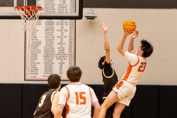 Lincoln-Way West's Wyatt Carlson (23) puts up a fade-away jumper over a Joliet Catholic defender during a nonconference game in New Lenox on Saturday, Feb. 15, 2025. (Vincent D. Johnson / for the Daily Southtown)