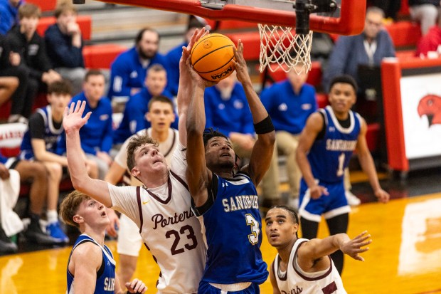 Sandburg's William Johnson (3) draws some contact from Lockport's Collin Miller (23) on his way to the basket during the Class 4A Marist Regional semifinals in Chicago on Wednesday, Feb. 26, 2025. (Vincent D. Johnson / for the Daily Southtown)