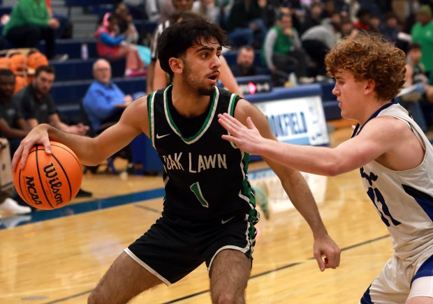 Oak Lawn's Ali Farhan, left, looks to pass as Riverside-Brookfield's Vincent Dockendorf, right, defends during the boys basketball game in Riverside on Saturday, Feb. 8, 2025. (James C. Svehla / for the Daily Southtown)