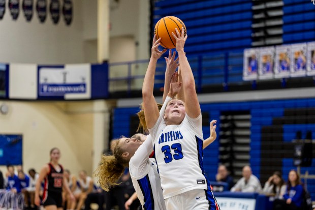 Lincoln-Way East's Kennedy Johnson (33) and Lincoln-Way East's Ellie Guyette, left, go up for the same rebound against Lincoln-Way Central during the Class 4A Lincoln-Way East Regional semifinals in Frankfort on Monday, Feb. 17, 2025. (Vincent D. Johnson / for the Daily Southtown)