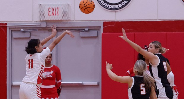 Homewood-Flossmoor's Zoey Ratliff (11) shoots for three points over Lincoln-Way West's Ava Tisch (5) and Molly Finn (10) during a basketball game in Flossmoor on Tuesday, Feb. 11, 2025. (John Smierciak / Daily Southtown)