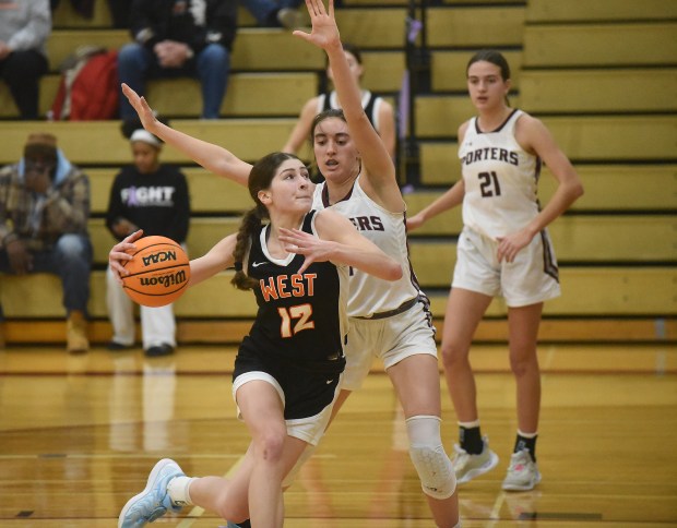 Lincoln-Way West's Caroline Smith (12) drives to the basket against Lockport's Alaina Peetz (44) during a SouthWest Suburban Conference game Tuesday, Feb. 4, 2025 in Lockport, IL. (Steve Johnston/for the Daily Southtown)