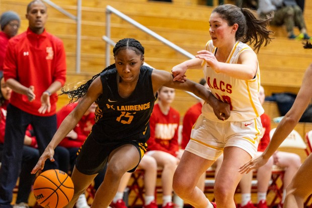 St. Laurence's McKenzie Saffold (15) drives past Mother McAuley's Delia Sullivan (10) during a GCAC first-round playoff game in Chicago on Monday, Feb. 3, 2025. (Vincent D. Johnson / for the Daily Southtown)