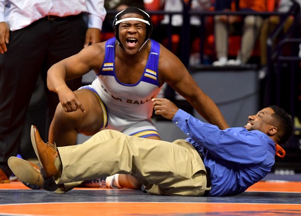 After winning his title match at 285 pounds De La Salle's David McCarthy celebrates with his coach in the Class 1A 1st place match at the IHSA Wrestling individual state meet at the University of Illinois' State Farm Arena in Champaign, Saturday Feb. 22, 2025. (Rob Dicker / for the Daily Southtown)