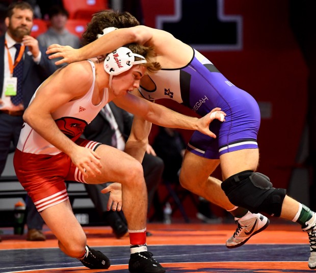 Marist's Will Denny tries to avoid being taken down by Hononegah's Brody Sendele during their 165 pounds in the Class 3A 1st place bout at the IHSA Wrestling individual state meet at the University of Illinois' State Farm Arena in Champaign, Saturday Feb. 22, 2025. (Rob Dicker / for the Daily Southtown)