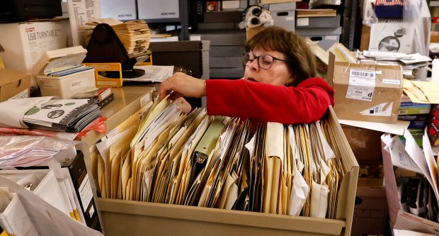 Jane Nicoll, museum director, looks for old maps inside the historical archives, which is housed at the Park Forest 1950s House Museum at St. Mary Church's school. The museum and archives are located inside the former classrooms, is facing an uncertain future with the potential closure by the Joliet Diocese. The museum and historical archive is shown here on Friday, Feb.7, 2025 (John Smierciak / Daily Southtown)