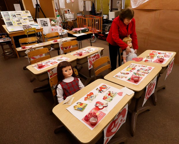 Jane Nicoll, museum director, adjusts a dolls dress inside the Park Forest 1950s House Museum on Friday, Feb. 7. The museum as well as the Park Forest Historical Archive, is housed at St. Mary Church's former school.(John Smierciak / Daily Southtown)