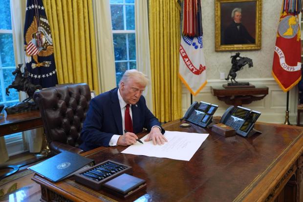 President Donald Trump signs executive orders in the Oval Office at the White House, Thursday, Jan. 30, 2025, in Washington. (AP Photo/Evan Vucci)