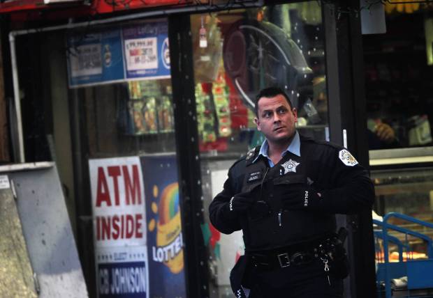 Chicago Police investigate the scene where off-duty Officer Clifton Lewis was shot and killed overnight at an Austin neighborhood convenience store, Dec. 30, 2011. (E. Jason Wambsgans/Chicago Tribunea)