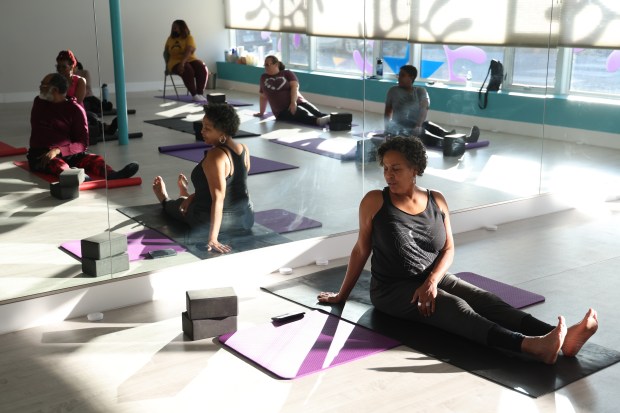 Julia Perkins, right, teaches a yoga class at her business, Studio Yogi, in Chicago's South Shore neighborhood on Dec. 13, 2023. (Terrence Antonio James/Chicago Tribune)