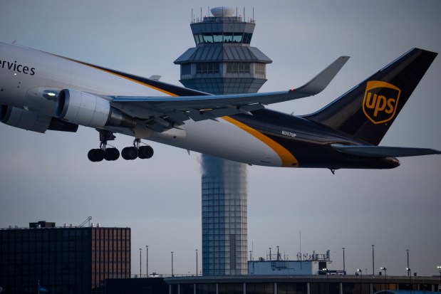 A UPS cargo jet takes off in front of one of the three FAA air traffic control towers at O'Hare International Airport on Jan. 29, 2025. (E. Jason Wambsgans/Chicago Tribune)