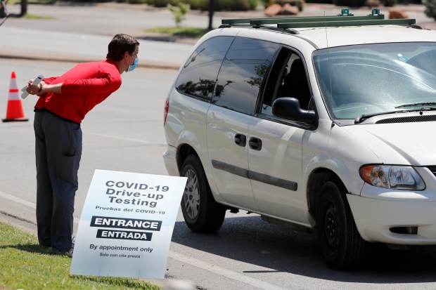 A Walgreens employee talks with a person in line for COVID-19 testing in Dallas, April 25, 2020. (Tony Gutierrez/AP)