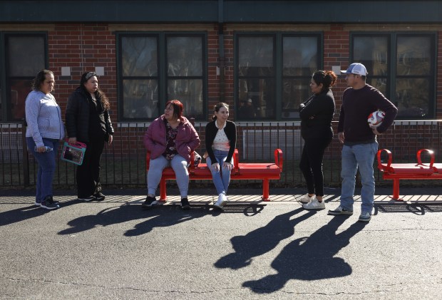 Regina Tafolla, center, talks with fellow parents of students at Volta Elementary School while watching their children play during a professional development day off for students on Feb. 25, 2025. (John J. Kim/Chicago Tribune)