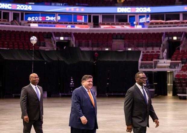 DNC chair Jaime Harrison, from left, Gov. JB Pritzker and Mayor Brandon Johnson arrive to speak during a walkthrough of the Democratic National Convention on May 22, 2024, at the United Center. (Brian Cassella/Chicago Tribune)