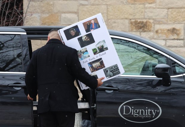 A funeral worker carries in a memorial board containing photos of Chicago Bears owner Virignia McCaskey on Feb. 12, 2025, at St. Emily Catholic Church in Mount Prospect. (Stacey Wescott/Chicago Tribune)