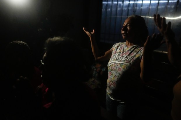 A woman prays during an evening Mass where the priest offered up prayers for the good health of Pope Francis, amid a power outage in Buenos Aires, Argentina on Feb. 22, 2025. (Natacha Pisarenko/AP)