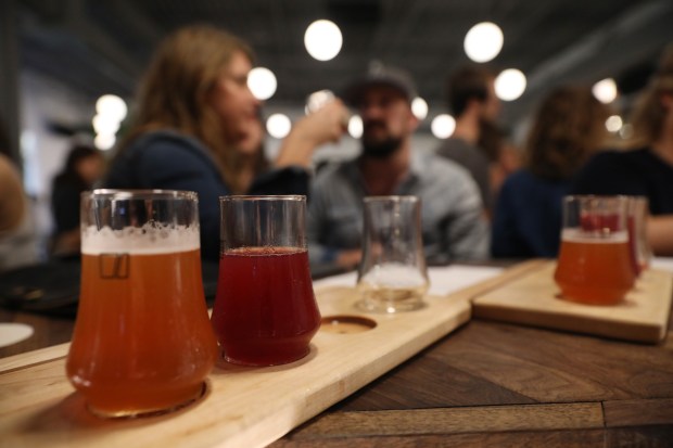 Patrons drink flights of Luna Bay Booch Co. hard kombucha during the brand's launch party at Pilot Project Brewing on North Milwaukee Avenue in Chicago, Sept. 27, 2019. (John J. Kim/Chicago Tribune)