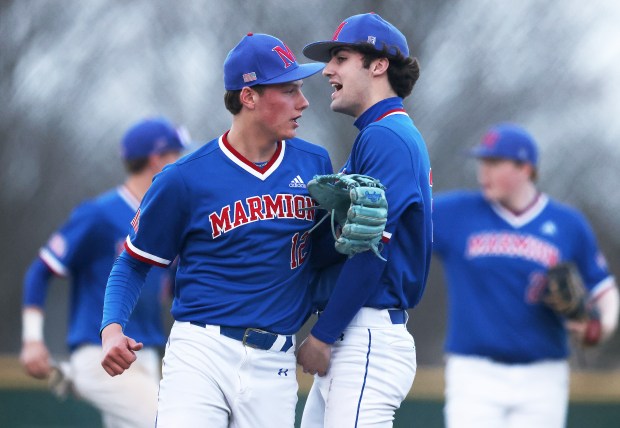 Marmion's Edward Morvice (12), left, and starting pitcher Jack Hughes (22) react to Marmion's win over Waubonsie Valley during a non conference game in Aurora on March 18, 2025.H. Rick Bamman/for the Beacon-News