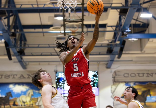 West Aurora's Terrence Smith (5) leaps for the net at the Class 4A Downers Grove South Regional final in Downers Grove on Friday, Feb. 28, 2025. (Nate Swanson/for the Beacon-News)