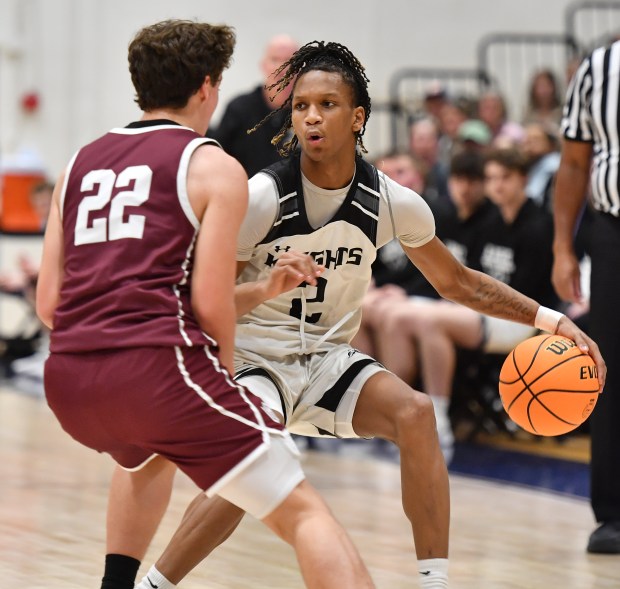 Kaneland's Isaiah Gipson shields the ball from Wheaton Academy's Joel Baarman (22) during the Class 3A IMSA Regional championship game on Friday, Feb. 28, 2025 in Aurora...(Jon Cunningham/for The Beacon-News)