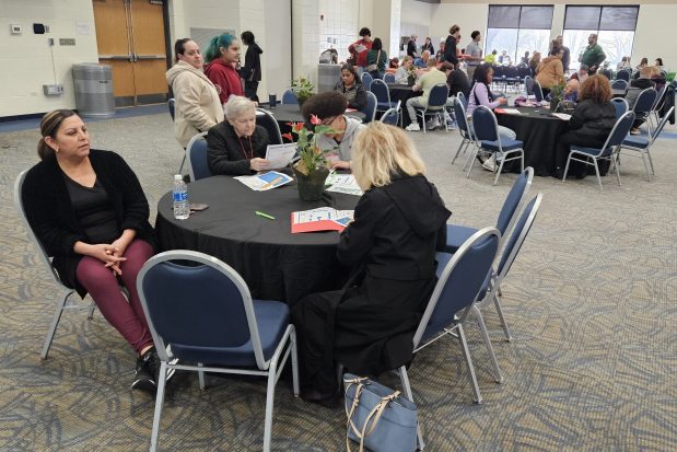 Potential employees fill out applications and wait for interviews Saturday at the Prisco Community Center in Aurora during the Fox Valley Park District Job Fair. (David Sharos / For The Beacon-News)