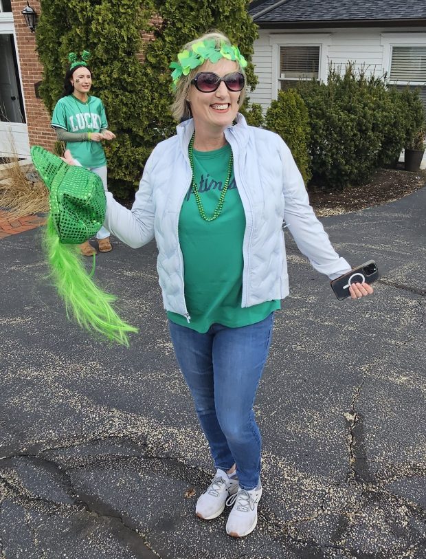 Melissa Christensen of Itasca dances as the annual St. Patrick's Parade is set to begin in St. Charles Saturday. (David Sharos / For The Beacon-News)