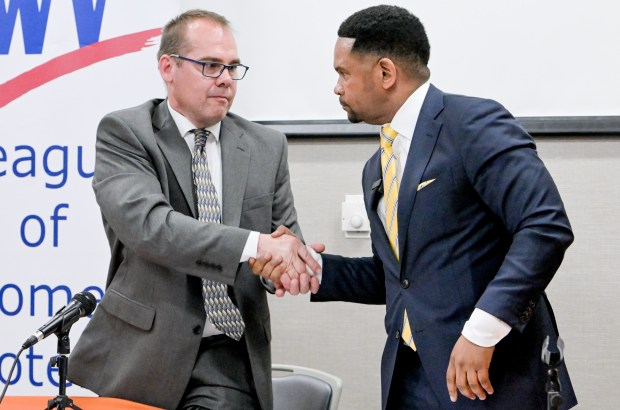 Aurora mayoral challenger John Laesch, left, and incumbent Richard Irvin shake hands after a mayoral forum at the Santori Public Library in Aurora, March 10, 2025. (Mark Black/for the Beacon-News)