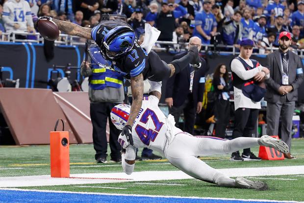 Lions wide receiver Tim Patrick dives over Bills cornerback Christian Benford to score Dec. 15, 2024, in Detroit. (AP Photo/Rey Del Rio)