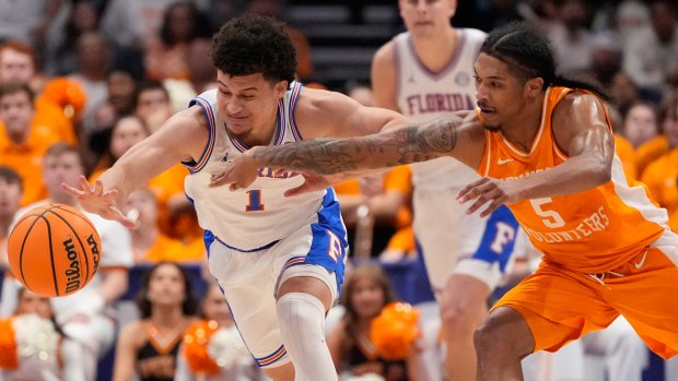 Florida guard Walter Clayton Jr. (1) and Tennessee guard Zakai Zeigler chase a loose ball during the SEC Tournament final Sunday, March 16, 2025, in Nashville, Tenn. (AP Photo/George Walker IV)