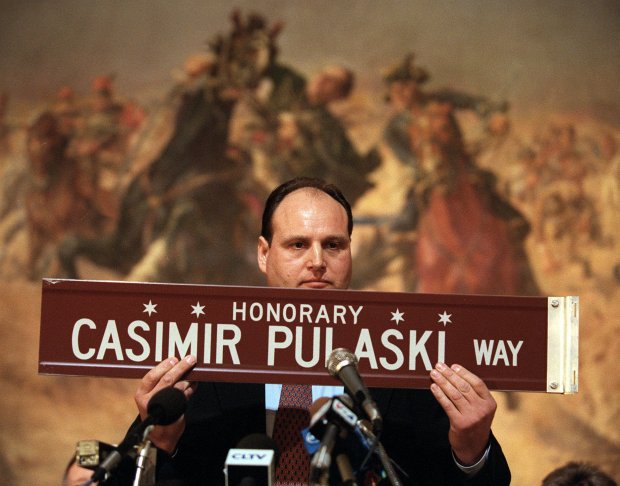 Ald. Michael Wojcik (30th Ward) holds up a new street sign honoring Casimir Pulaski on Pulaski Road. The alderman and a host of dignitaries were at the Polish Museum of America's Great Hall for the annual Pulaski Day celebration, honoring the Revolutionary War hero Casimir Pulaski. The painting "The Death of General Casimir Pulaski," by Stanislaw Batowski, depicts his death at Savannah, GA. in 1779. Photo by Chuck Berman. 23137.6 Tribune photo by Chuck Berman 3/6/2000 NO MAGS/NO SALES/NO INTERNET ORG XMIT: 000306/23137.6