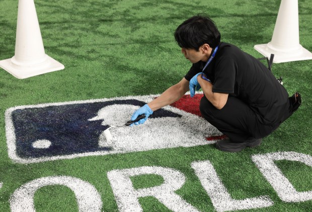 A worker fills in the Major League Baseball logo for the Tokyo Series after workouts from the Cubs and Dodgers at the Tokyo Dome on March 17, 2025, in Tokyo. The teams play on March 18 in Tokyo to start the regular season. (John J. Kim/Chicago Tribune)