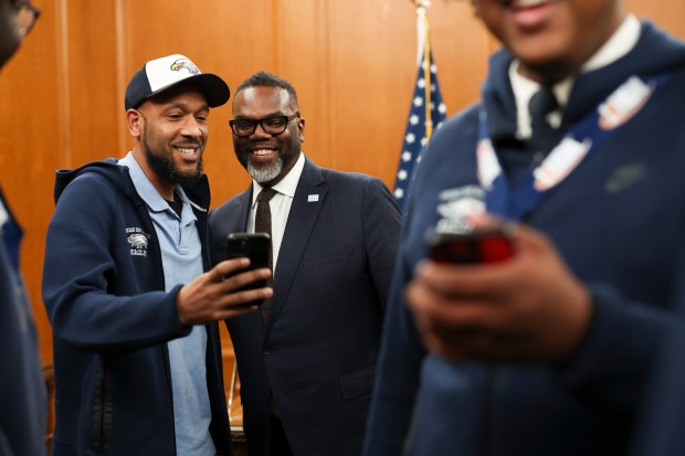 Mayor Brandon Johnson takes a photo with Chicago Hope Academy basketball assistant coach Steve Warren while the team was being honored for their high school state championship in the mayor's ceremonial office at City Hall, March 20, 2025. (Eileen T. Meslar/Chicago Tribune)