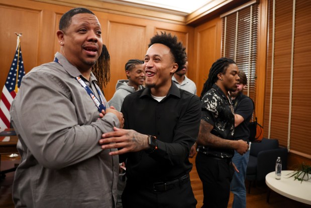 Dyett High School basketball team head coach Jamaal Gill and assistant coach Nathaniel Townsen Jr. laugh after Mayor Brandon Johnson honored their team for their high school state championship in the mayor's ceremonial office at City Hall, March 20, 2025. (Eileen T. Meslar/Chicago Tribune)