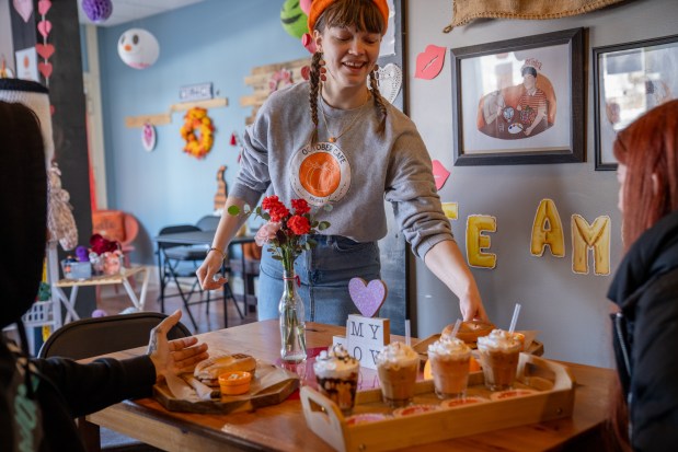 Co-owner Audrey Borden delivers a coffee flight for customers at Coffee Shop of the Year October Cafe in Chicago on Feb. 22, 2025. (Audrey Richardson/Chicago Tribune)