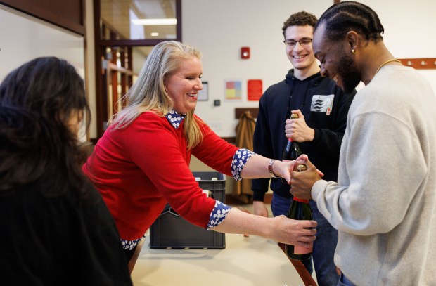 Master sommelier and adjunct professor Jill Zimorski, left, shows Marvin Gibson, 21, right, and Carter Wideman, 22, center, how to open a bottle of brut rose while teaching a course on wine and beverage management at DePaul University in the Loop on March 11, 2025. (Armando L. Sanchez/Chicago Tribune)