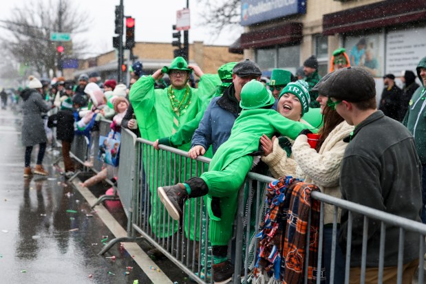 A child gets lifted over a barrier during the South Side Irish Parade on Western Avenue in Beverly and Morgan Park on March 16, 2025. (Eileen T. Meslar/Chicago Tribune)