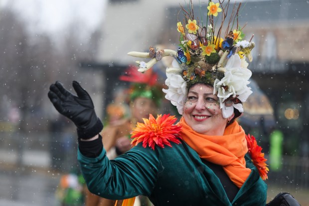 A woman waves as she march south on Western Avenue in the South Side Irish Parade on March 16, 2025. (Eileen T. Meslar/Chicago Tribune)