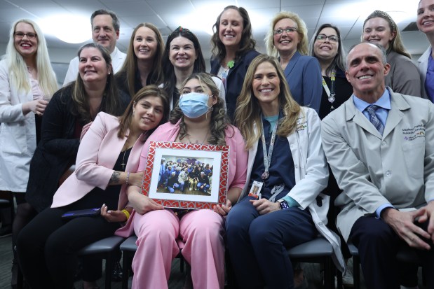 Nataly Paramo, second from left, the first pediatric patient to receive a heart transplant at Advocate Children's Hospital, pose for a group photo with her mother, doctors and medical staff following a press conference at Advocate Children's Hospital on March 5, 2025. (Antonio Perez/Chicago Tribune)