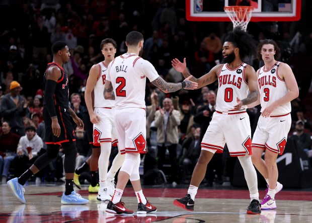 Bulls guards Lonzo Ball (2) and Coby White (0) celebrate in overtime against the Raptors on Feb. 28, 2025, at the United Center. (Chris Sweda/Chicago Tribune)