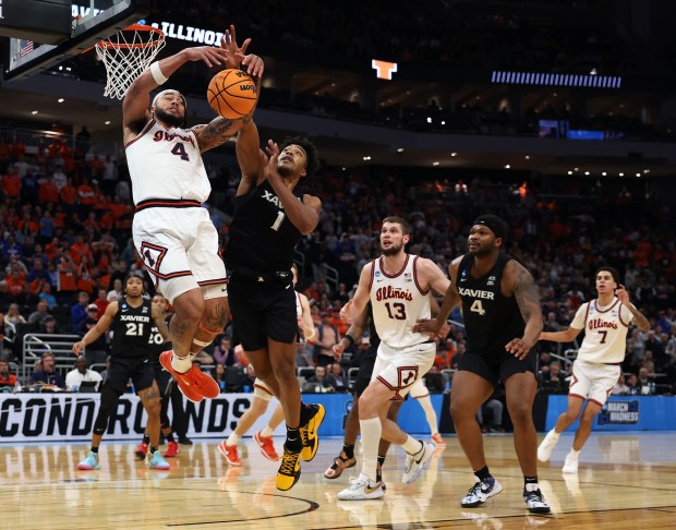 Illinois guard Kylan Boswell (4) pulls down a rebound beside Xavier guard Marcus Foster in the second half of an NCAA Tournament game on March 21, 2025, at Fiserv Forum in Milwaukee. (Chris Sweda/Chicago Tribune)