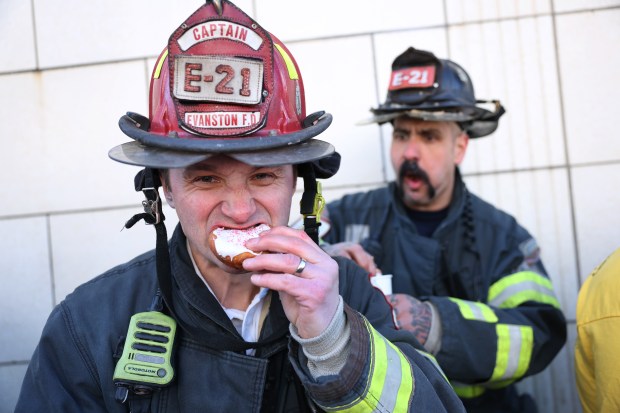 Evanston firefighters Damien Bazan and Andrew Jakus participate in the annual paczki eating contest at Bennison's Bakery in Evanston, March 1, 2025. (Chris Sweda/Chicago Tribune)