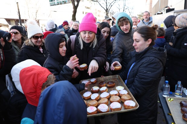 Free paczki are given out after the annual paczki eating contest at Bennison's Bakery in Evanston on March 1, 2025. (Chris Sweda/Chicago Tribune)