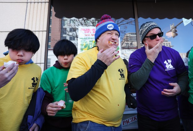 Participants chew the Polish treats at the annual paczki eating contest held by Bennison's Bakery in Evanston on March 1, 2025. (Chris Sweda/Chicago Tribune)