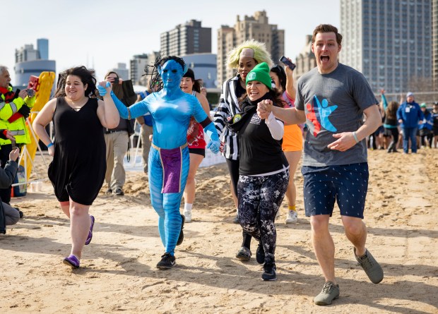 The first wave of participants run into Lake Michigan on March 2, 2025, during the annual Polar Plunge benefitting Special Olympics Illinois. (Brian Cassella/Chicago Tribune)