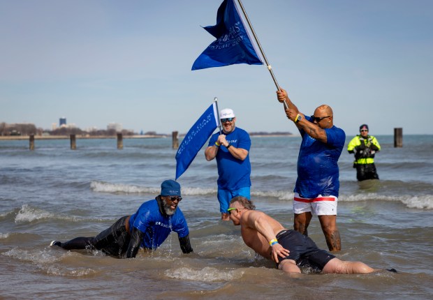 Participants do pushups in Lake Michigan during the annual Polar Plunge benefitting Special Olympics Illinois. (Brian Cassella/Chicago Tribune)