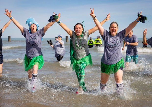 Participants run into Lake Michigan with temperatures in the 20s during the annual Polar Plunge. (Brian Cassella/Chicago Tribune)