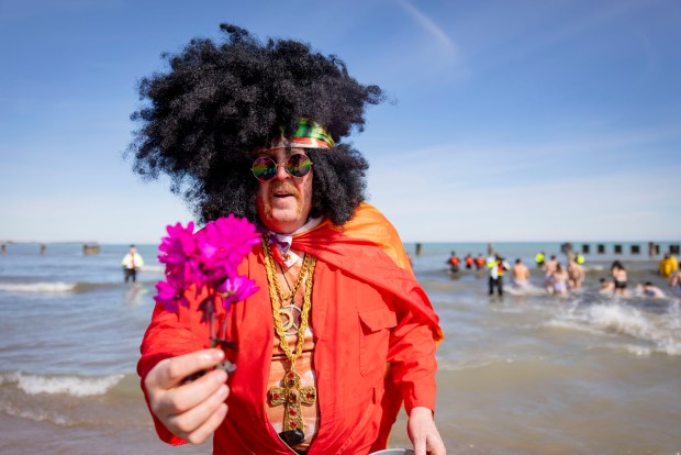 A costumed partcipant offers flowers after running into Lake Michigan with temperatures on March 2, 2025, during the annual Polar Plunge. (Brian Cassella/Chicago Tribune)