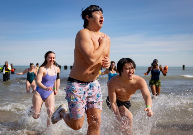 Participants splash into Lake Michigan at North Avenue Beach with temperatures in the 20s on Sunday, March 2, 2025, during the annual Polar Plunge benefiting Special Olympics Illinois. About 4,800 people dove into the 35-degree water. (Brian Cassella/Chicago Tribune)